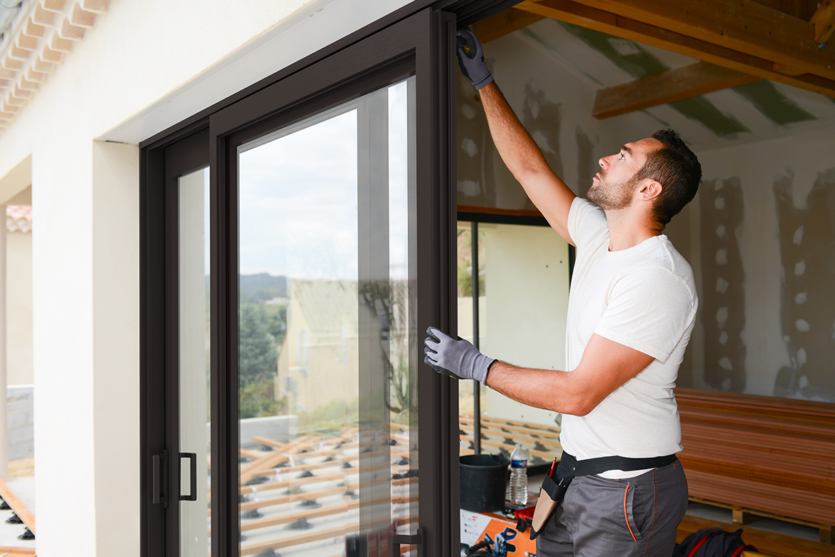 A certified installer working on an impact resistant sliding glass door